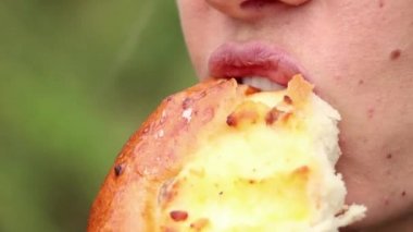 Parktaki sokakta rulo yiyip kahve içen, kız içen ve yakın plan yemek yiyen bir kızın ağzı.
