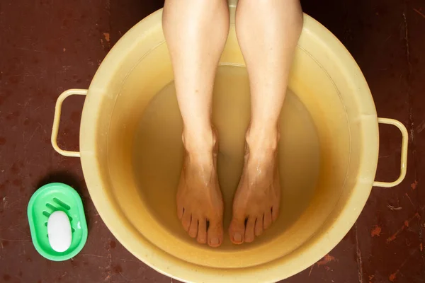 Flicka Tvättar Fötterna Skål Med Vatten Trägolvet Hemma Fotvård Tvätta — Stockfoto