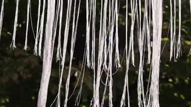 薄い白いロープで作られたシャンデリア空を背景に風の中で通りに重さと揺れ瞑想のためのビデオ — ストック動画