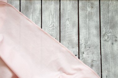 Pembe buruşuk masa örtüsü arka planda yakın plan olarak beyaz bir ahşap masada yatıyor.