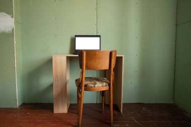 Beyaz ekranlı siyah bir dizüstü bilgisayar evdeki bir odada, beyaz ekranlı bir dizüstü bilgisayarın üzerinde duruyor.