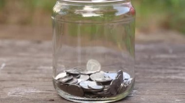 Ukrayna sikkelerini şeffaf cam bir kavanoza at, kavanoza para dök, para topla, finans
