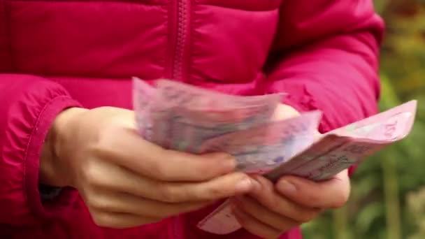 女孩在街上考虑面值为200格里夫尼亚的法案 乌克兰人的钱在女孩手里 200格里夫尼亚 — 图库视频影像