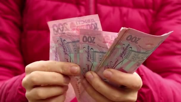 女孩在街上考虑面值为200格里夫尼亚的法案 乌克兰人的钱在女孩手里 200格里夫尼亚 — 图库视频影像