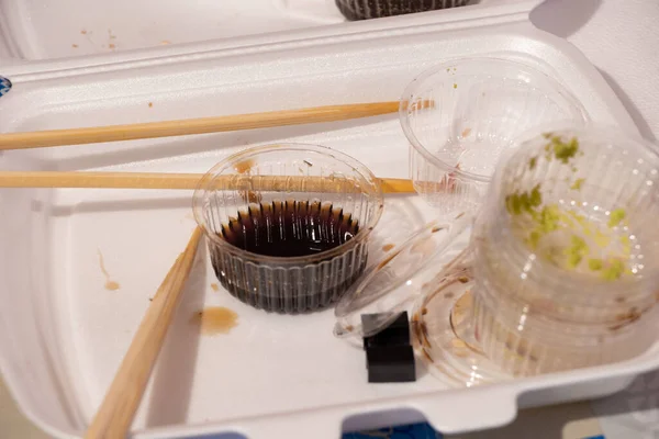 夕食のテーブルの上のプラスチック包装に店内の寿司がセットになっていて自宅のテーブルに寿司が置かれていてプラスチック使い捨て寿司包装 — ストック写真