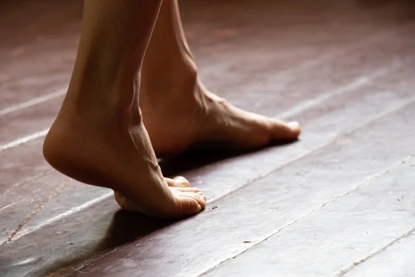 Ragazza in piedi a piedi nudi sul vecchio pavimento di legno sporco della casa nella stanza, piedi femminili sul pavimento — Foto Stock