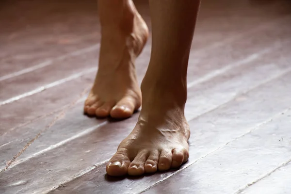 Dívka stojí bosá na staré špinavé dřevěné podlaze domu v pokoji, ženské nohy na podlaze — Stock fotografie