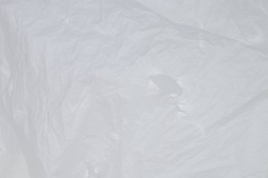 Hafif yansımaları olan şeffaf polietilen arka plan, beyaz arka planda buruşmuş plastik, model, tasarım veya endüstriyel kullanım için ambalaj malzemesi dokusu