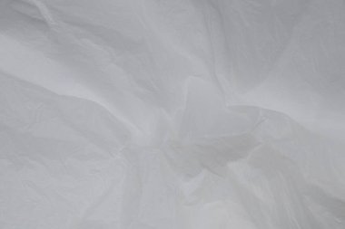 Hafif yansımaları olan şeffaf polietilen arka plan, beyaz arka planda buruşmuş plastik, model, tasarım veya endüstriyel kullanım için ambalaj malzemesi dokusu