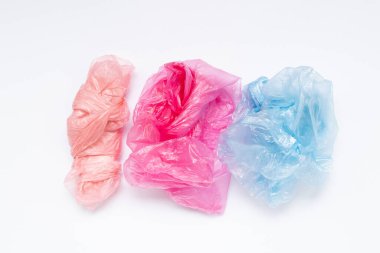 Çok renkli buruşmuş plastik torbalar beyaz arka planda yatıyor.