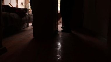 İnsanlar, çok katlı bir binanın yakınındaki bir İHA 'nın patlaması sonucu bir pencereden patlayan ve Ukrayna' daki bir daireye zarar veren patlama dalgasının ardından temizlik yapıyorlar.