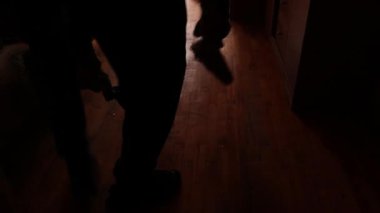 İnsanlar, çok katlı bir binanın yakınındaki bir İHA 'nın patlaması sonucu bir pencereden patlayan ve Ukrayna' daki bir daireye zarar veren patlama dalgasının ardından temizlik yapıyorlar.