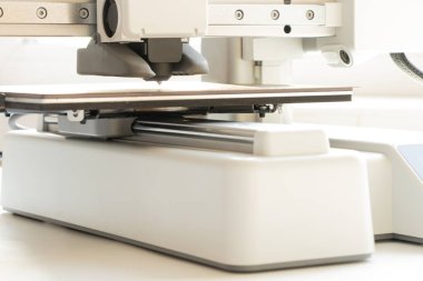 Beyaz arkaplanda bir masaüstü 3D yazıcısı. Katkı sağlayan üretim, dijital eğitim ve prototipleme için modern teknolojiler