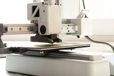 Beyaz arkaplanda bir masaüstü 3D yazıcısı. Katkı sağlayan üretim, dijital eğitim ve prototipleme için modern teknolojiler