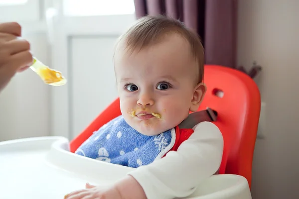 Sulky vlekkerig baby weigert te eten van een maaltijd Stockfoto