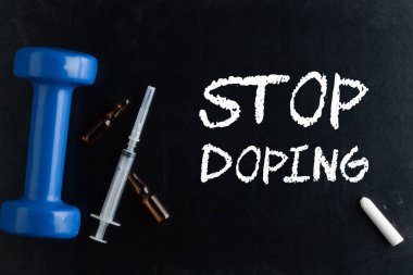 Tahtaya tebeşir, dambıl, şırınga ve ampul ile yazılmış Doping durdurun.