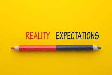 The words Expectation vs Reality with pencil on yellow background. clipart