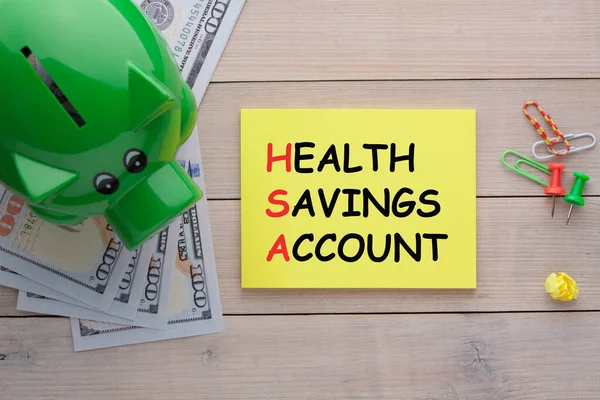 Health Savings Account (HSA) text with a piggy bank and hundred dollar bills.