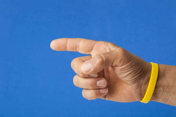 Hand Pointing Gesture Empty Yellow Bracelet Blue Background Communication Bracelet — 图库照片
