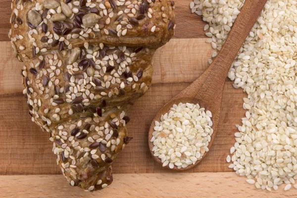 Croissant de trigo integral y semillas de sésamo en cuchara de madera — Foto de Stock