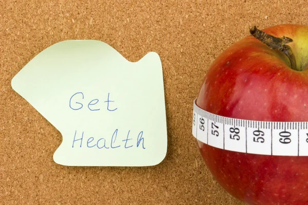 Obtener Salud twritten en nota adhesiva y manzana —  Fotos de Stock