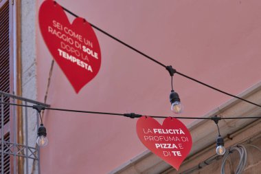 Colorful Italian alley with red heart signs and romantic phrases about love and pizza, symbol of Italian joy