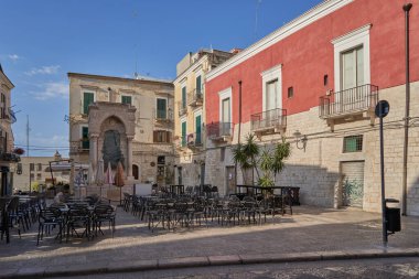 Italian town square with empty caf tables, colorful facades, and warm afternoon sunlight inviting  