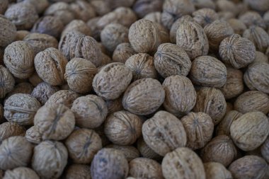 Geleneksel bir pazarda sergilenen cevizlerin ayrıntılı görünümü, Akdeniz lezzetlerini ve otantik seyahat gıda deneyimlerini vurguluyor.