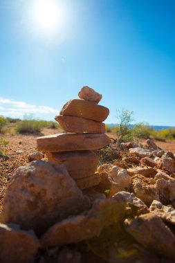Arka plan gökyüzü, kum ve taş ile yere taş piramit