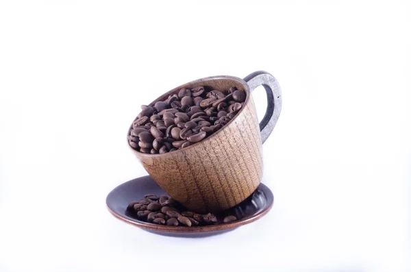 Caneca de madeira cheia de grãos de café e grãos de café espalhados o — Fotografia de Stock