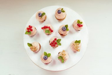 Küçük kek krem, yaban mersini, kızılcık ve kuş üzümü. 