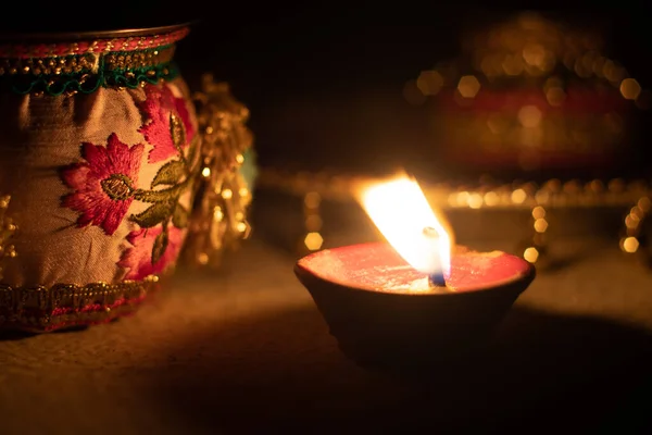 Bloqueado en tiro que muestra una lámpara de aceite diya ardiendo brillante en el festival hindú de diwali con hermoso bokeh en el fondo y artículos decorativos cercanos — Foto de Stock