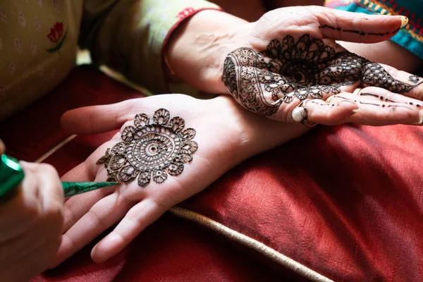 Felülről lefelé videó egy nőről, aki egyik kezéről a másikra másolja a mehndi henna tetoválást a teej, karwachauth, diwali dussera vagy házassági esemény hindu fesztiváljának előkészítése céljából. — Stock Fotó