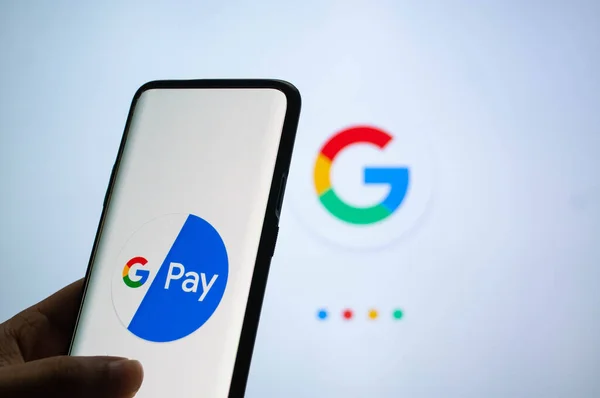 Google Pay app συνδεδεμένοι σε ένα κινητό μπροστά από μια λευκή οθόνη με το σύμβολο Google — Φωτογραφία Αρχείου