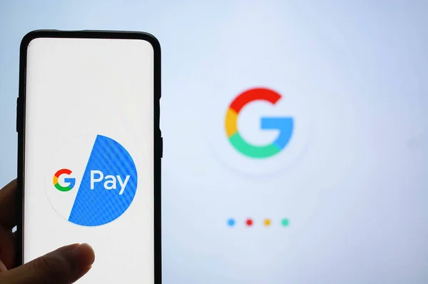 Google Pay app συνδεδεμένοι σε ένα κινητό μπροστά από μια λευκή οθόνη με το σύμβολο Google — Φωτογραφία Αρχείου