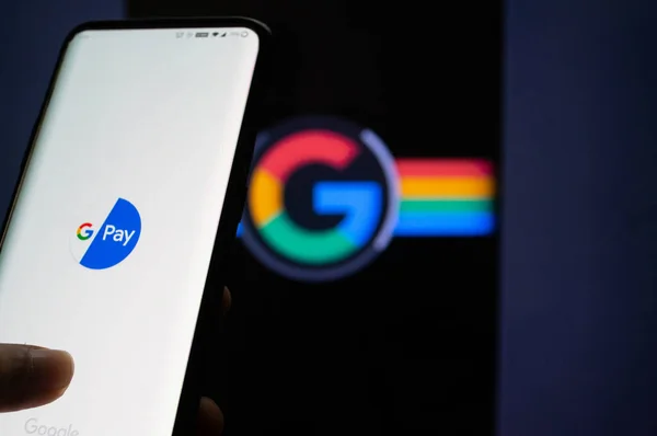 Google Pay app συνδεδεμένοι σε ένα κινητό μπροστά από μια μαύρη οθόνη με το σύμβολο Google — Φωτογραφία Αρχείου