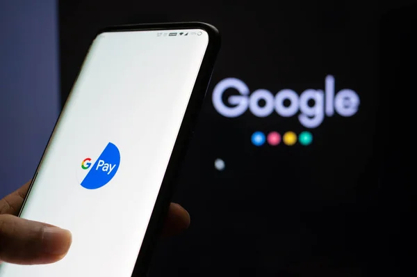 Google Pay app συνδεδεμένοι σε ένα κινητό μπροστά από μια μαύρη οθόνη με το σύμβολο Google — Φωτογραφία Αρχείου