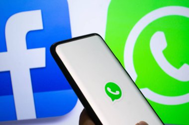 Bir logo ekranının önündeki Whatsapp mobil uygulamasına bağlanmış bir mobil