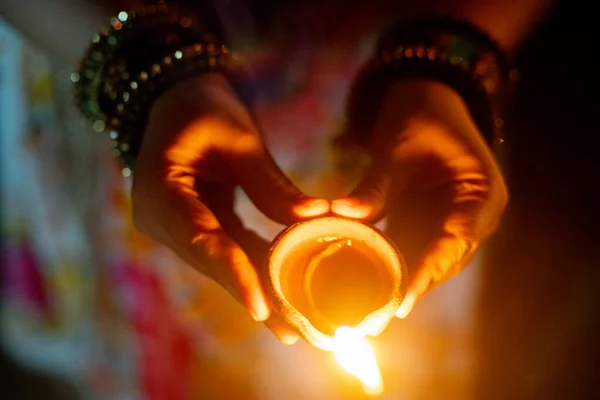 Tiro de cima para baixo de mão segurando lâmpada de óleo diya em forma de coração espalhar amor e alegria no festival hindu de diwali — Fotografia de Stock