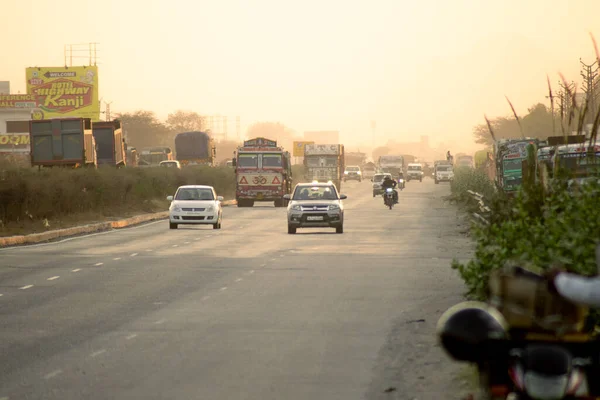 Сутінковий постріл автомобіля, який стрибає червоним світлом, тоді як інші автомобілі і два колеса чекають, поки світло зміниться на перехресті в Гургаоні. — стокове фото