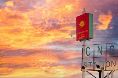 Indraprastha doğalgaz tabelası, CNG istasyonunu bulutlu bir muson yağmuruna karşı sınırladı. Hindistan 'daki en büyük doğal gaz tedarikçilerinden birini gösteriyor.