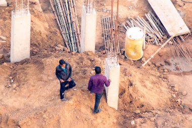 İnşaat işçileri inşaat mühendisleri müfettişleri müfettişlik gelişimi yetkili kişiler inşaat gayrimenkul geliştirme projesinin direkleri ölçüp kontrol ediyorlar.