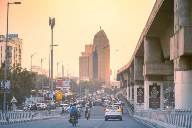 Hindistan 'ın başkenti Rajasthan' ın işlek caddesinde yükselen yüksek gökdelen binalarını gösteren günbatımı görüntüleri.