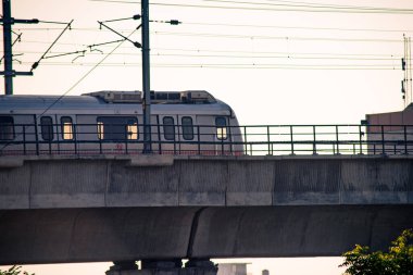 Yükseltilmiş köprüdeki metro treninin hava alacakaranlık görüntüleri şeffaf pencere ve kablolardan görülebilen insanlar ve görünür destek