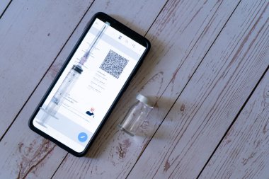 Dijital covid 19 Coronavirus aşı sertifikası olan cep telefonu. Şırınga ve boş bir şişe ile gösterilen Eş-WIN Cowin uygulamasında iki doz kovishield covaxin alındıktan sonra verilmiştir.