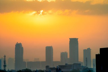Bulutlu alacakaranlık vuruşu güneş gizlenmiş ve sis bulutları gökdelenler çok katlı Gurgaon, Mumbai, bangalore şehir binaları Hindistan 'da musonlar sırasında.