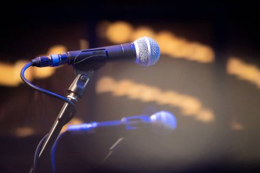 Konser müzik mikrofonları, odağını kaybetmiş bokeh ışık toplarıyla bir bar barında stand-up canlı performans müziği gösteriyor dünya Coronavirus COVID salgınının kilidini açıyor.