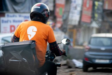 Bisikletçi kasklı ve hızlı bir tişörtle gıda teslimatının hızlı büyümesini e-ticaret girişimlerini, tek boynuzlu atları ve onlara iş sağlayan işçileri gösteriyor.
