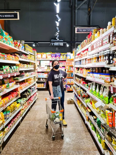 Jonge Indiaanse mannen en andere mensen die tijdens de COVID-coronaviruspandemie in het drukke gangpad van een supermarktketen op zoek zijn naar voedsel onder het dragen van maskers — Stockfoto