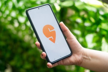 Üzerinde kadın logosu olan cep telefonu, yemek dağıtım teknolojisinin bulut mutfağıyla başladığını gösteriyor.